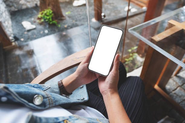 istock A woman holding mobile phone with blank desktop screen 1353602524