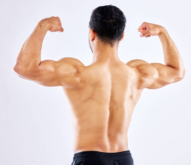 istock Shot of a man flexing his arm and back muscles against a studio background 1353602882