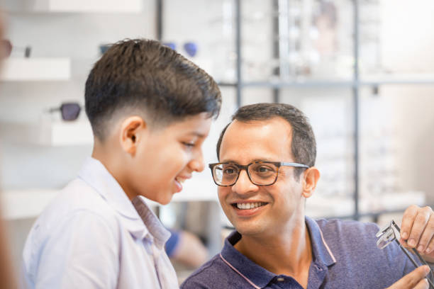 istock Indian father and son choosing eyeglasses in optics store 1353605902