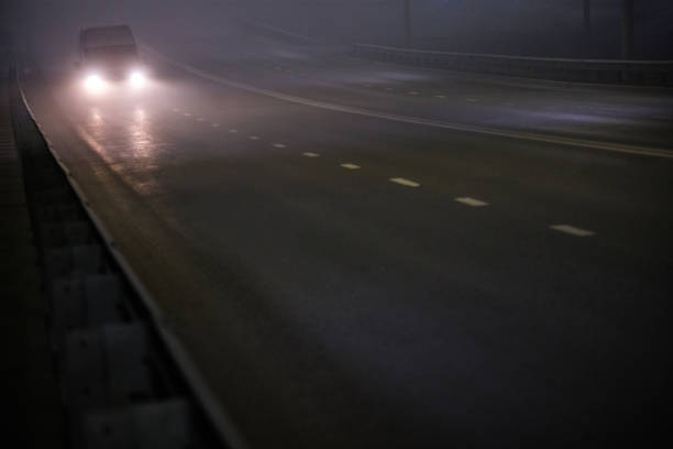 istock alone minivan moving on empty night foggy road 1353606230