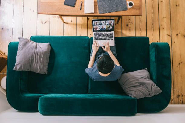 Man doing video call from home Young man doing video call from cozy home office. teleworking stock pictures, royalty-free photos & images