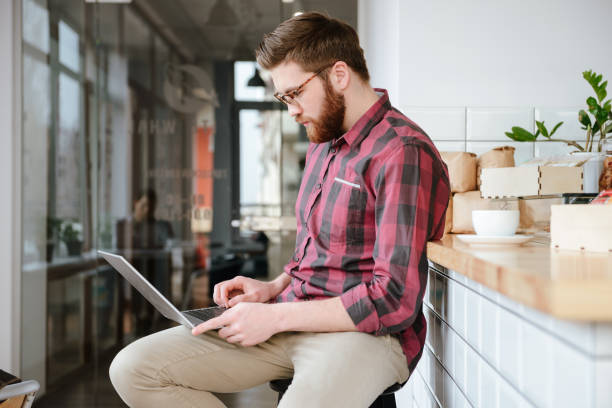 istock Attractive young man in eyeglasses sitting in cafe 1353607508