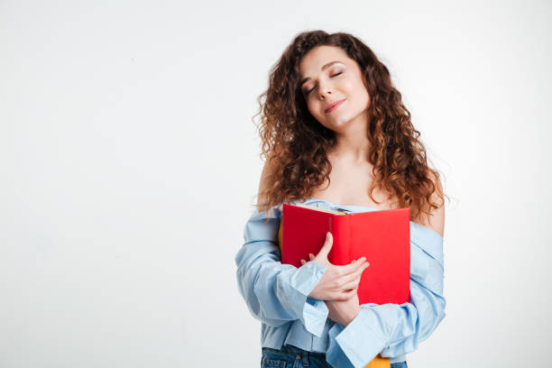 istock Woman holding book with closed eyes 1353608952