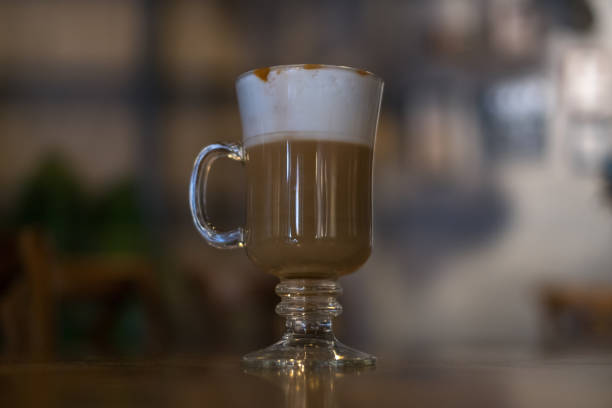 istock Glass cup with latte is on the table in coffee shop. 1353609093