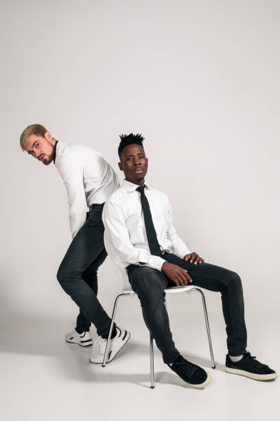 istock Two stylish men posing and having fun on white background 1353612191