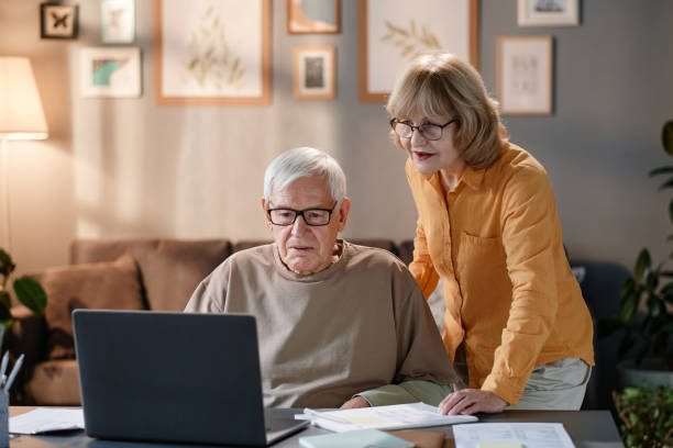 istock Senior couple using laptop at home 1353613595