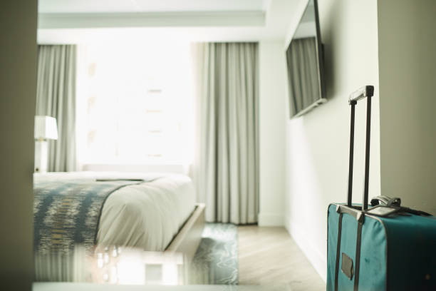 Businessman standing at window in hotel room and calling on phone