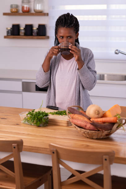 istock Woman drinking black coffee while preparing food. 1353615458