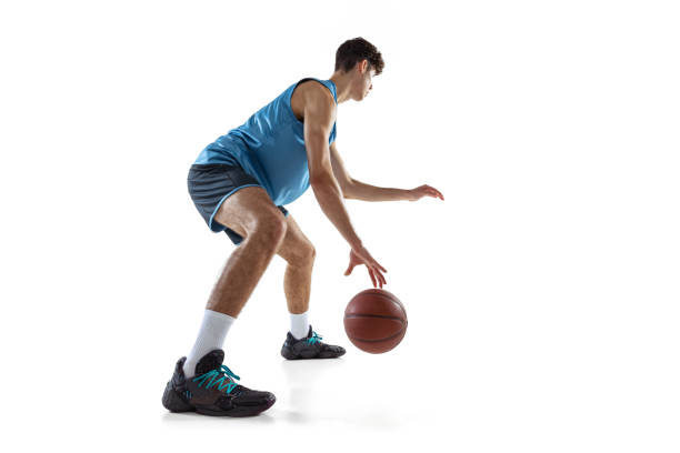 istock Full length portrait of basketball player practicing isolated on white studio background. Tall muscular athlete dribbling the ball. 1353616789