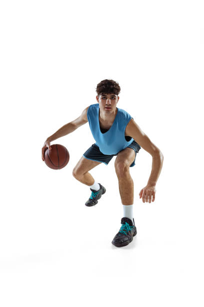 istock Dynamic portrait of basketball player practicing isolated on white studio background. Sport, motion, activity, movement concepts. 1353616794
