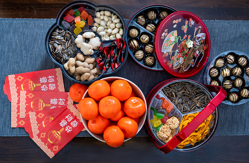 Red packets, oranges and traditional Chinese snacks for Chinese New Year Celebration.