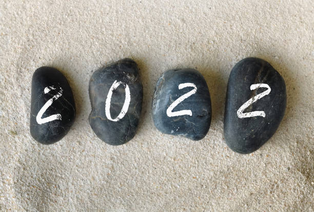 istock 2022 written on black pebbles on the sand 1353617434