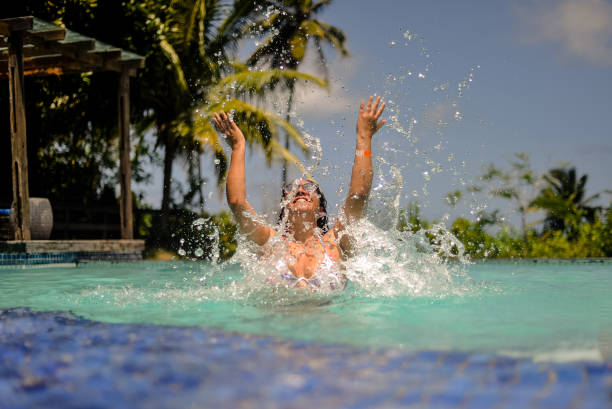 istock young woman throwing water into the pool 1353618722
