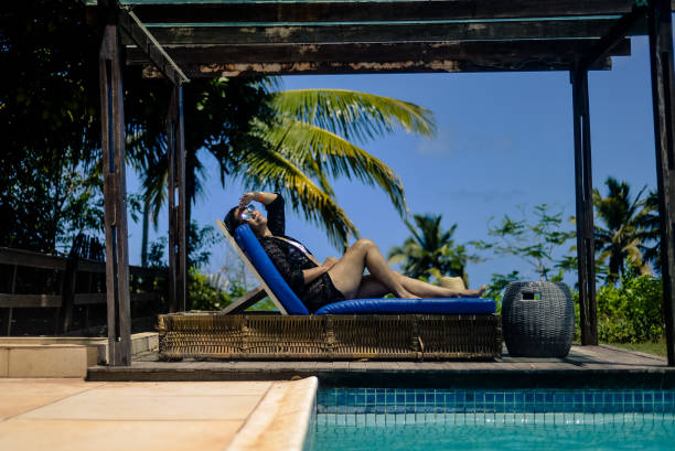 istock woman sunbathing by the pool. sunglasses 1353618733