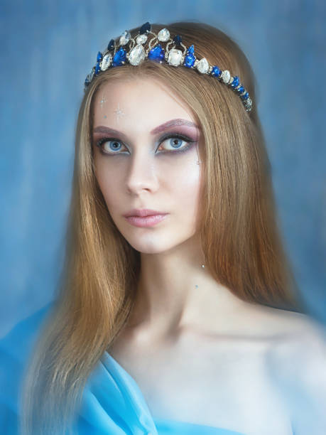 hermosa chica en una corona de piedras. con decoraciones de año nuevo. sobre fondo azul. retrato - ice maiden fotografías e imágenes de stock