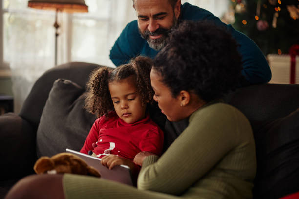 istock Parents and daughter using digital tablet at home 1353620191