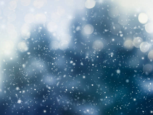 istock Abstract winter background. Falling snowflakes on a blurred background of trees. 1353622799