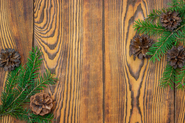 istock Brown wooden background with fir branches and cones 1353622845