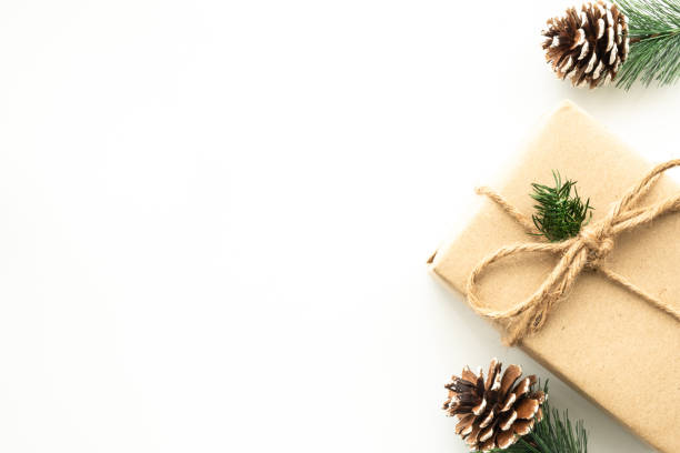 istock Beautiful Christmas background with gift box, decorate with pine branch and pine cone over white background. Top view with copy space, flay lay. 1353623104