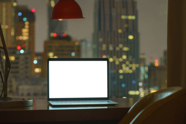 istock laptop computer on table white display see through city on night background 1353623352