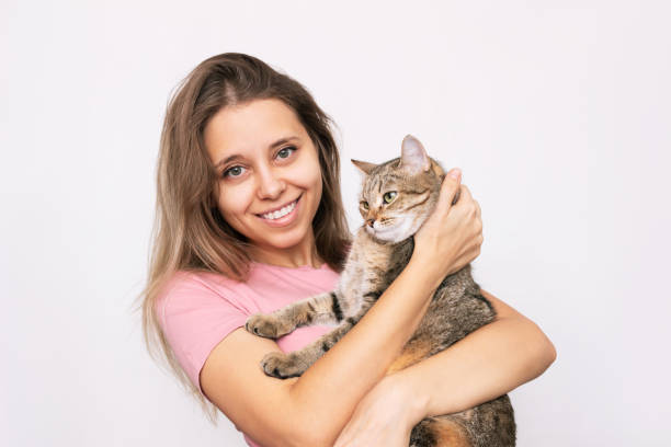 istock A young woman holding adorable Tabby cat in her hands 1353625131