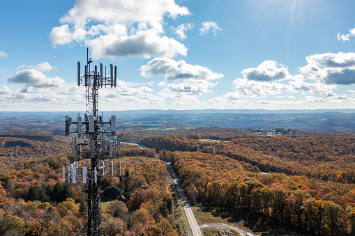 Aerial view of mobile phone cell tower over forested rural area of West Virginia to illustrate lack of broadband internet service