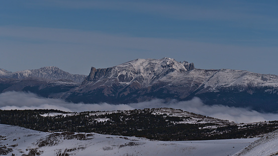 Beautiful view of the Rocky Mountains in late autumn with snow-capped peak of Mount Tekarra (2,694 m) in Jasper National Park, Alberta, Canada above cloud-covered Athabasca River Valley.