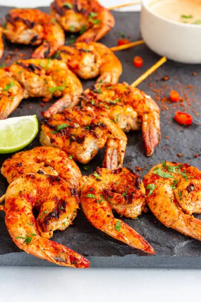 Piri Piri Grilled Shrimp on the Skewers with Lemon and Condiment on a Platter