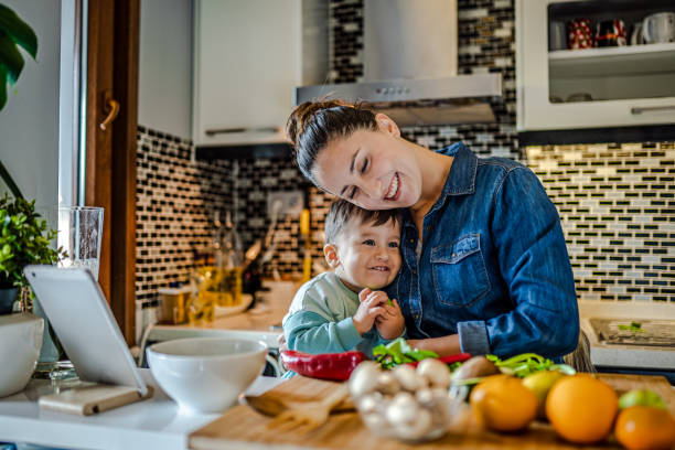 Young Mother teaches her son how to cook healthy food stock photo