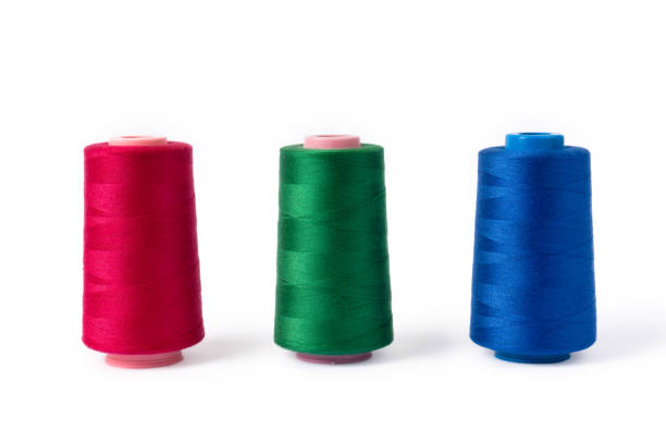 pink, blue and green threads on a white background. side view of colored sewing thread bobbins. - nylon strings imagens e fotografias de stock