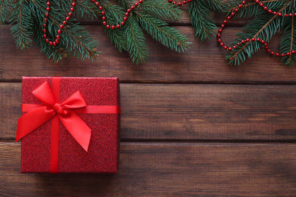 istock Gift box on wooden table with copy space and Christmas tree branches. Winter holidays concept 1353633029