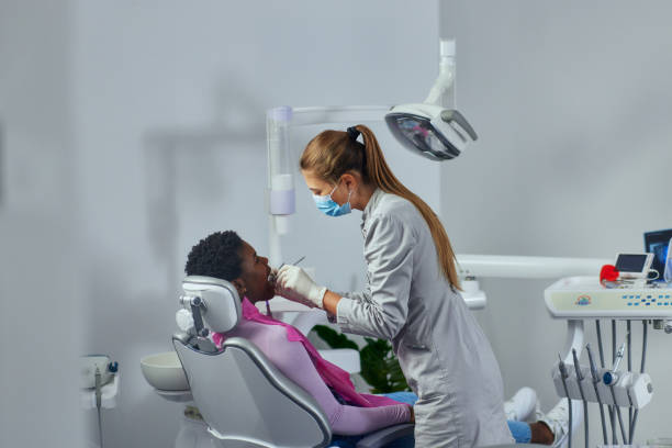 istock Afro patient getting a checkup at the dentist 1353633038