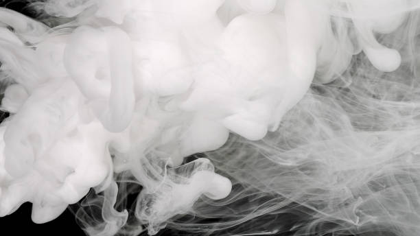 istock White ink is mixed in water on a black background. Space background. 1353633378