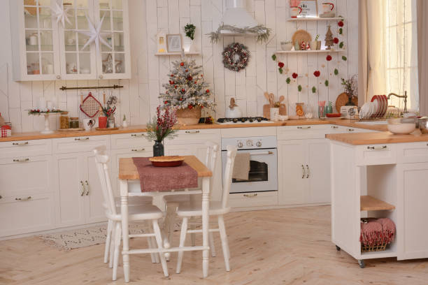 istock Interior of a light white ?hristmas kitchen with red decor elements in the Scandinavian style. Christmas decorations. Breakfast 1353633520