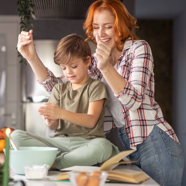 istock Mother and son baking cookies together at home 1353633523