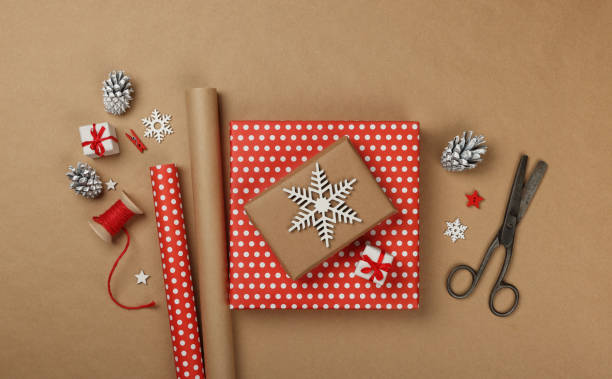 istock Packing Christmas gifts with red paper 1353636030