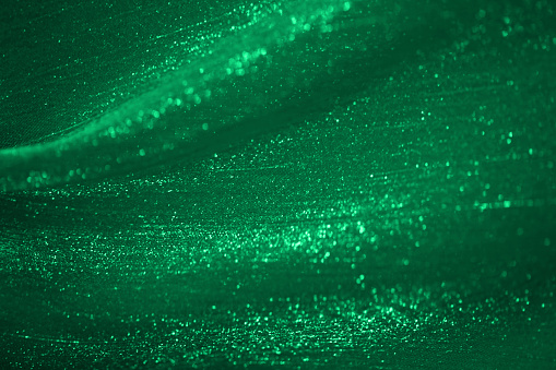 Christmas Green Glitter Background Abstract Emerald Glittering Dark Teal Wave Bokeh Lights Pattern Chiffon Satin Tulle Netting Textile Fantasy Texture St. Patrick's Day Silk Particle Dust Circle Backdrop Macro Photography Design template for presentation, flyer, card, poster, brochure, banner
