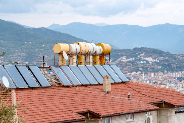 Barrels of water heated by solar panels installed on roof of house. Concept of saving electricity.