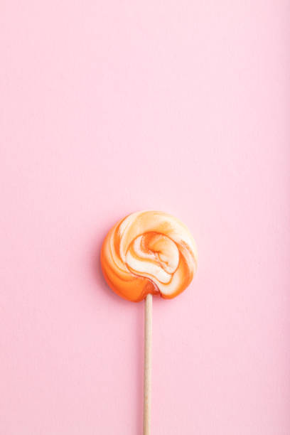 istock Single lollipop candy on pink pastel background. copy space, top view, flat lay. 1353644778