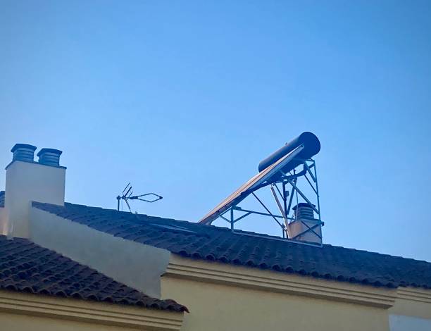 Solar panels for heating water on a roof next to a chimney