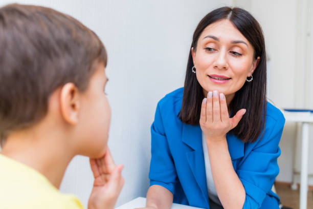 logopädin hilft einem jungen, die verletzung seiner sprache zu korrigieren - child speech therapy adult stock-fotos und bilder