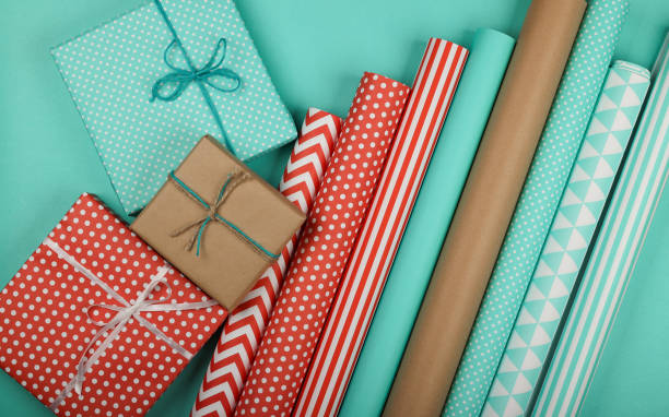 emballage de cadeaux avec du papier rouge bleu et brun - rolled up paper wrapping paper color image photos et images de collection