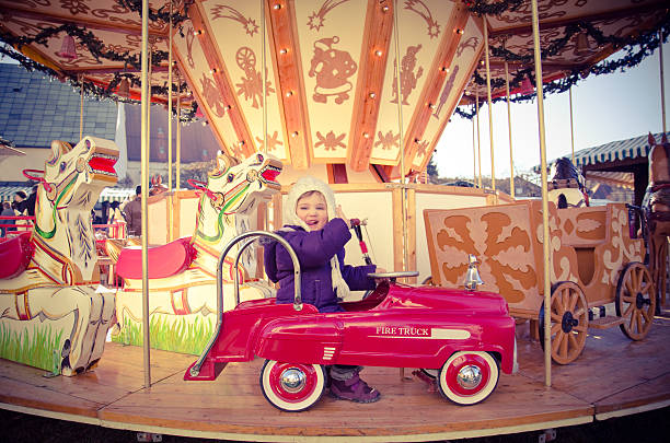 Little girl on a carousel in a fire truck