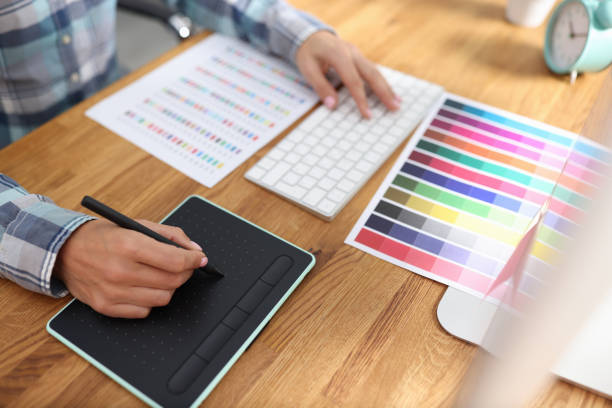 istock Graphic designer works on computer and selects color schemes 1353648801