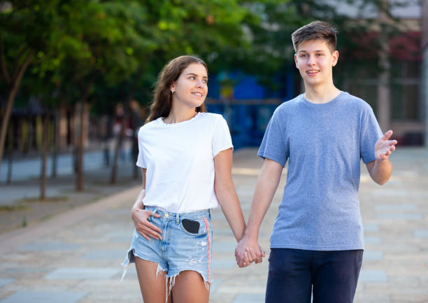 istock Two youngsters are walking hand in hand 1353649958