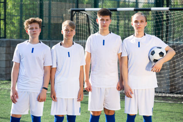 istock Young football team standing on pitch 1353650701