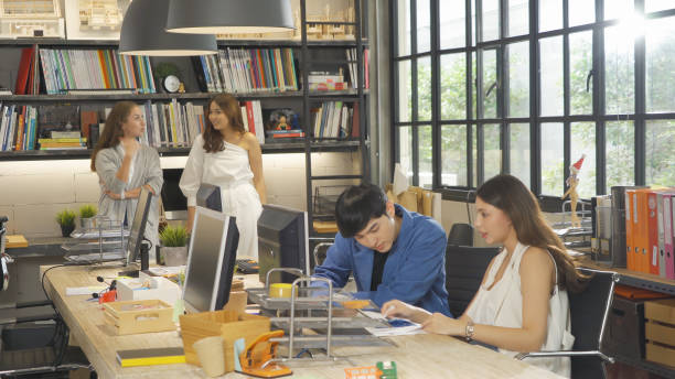 istock A group of multi ethnic business team talk, communicate, discuss, and work in meeting room in office, present ideas with a computer technology device to colleagues. People lifestyle. Corporation 1353650964