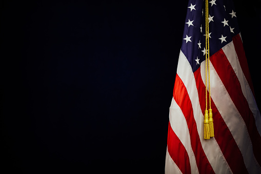 Shallow depth of field (selective focus) image with the US flag on a dark background.