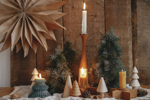 istock Christmas advent. Burning christmas candles, trees, paper star on rustic background. Happy holidays 1353654355