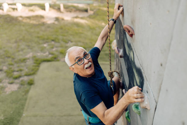 istock Senior man climbing on the artificial rock 1353655272
